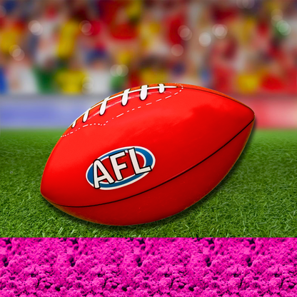 Sports Gender Reveal AFL Ball: Red Australian Football League ball positioned on green turf with bright pink powder effect below, set against a colorful bokeh background, perfect for gender reveal celebrations
