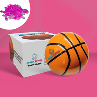 Gender Reveal Basketball shown with product box and pink powder packet against pink background. Traditional orange basketball with black stripes displayed next to white packaging featuring basketball design and brand logo.