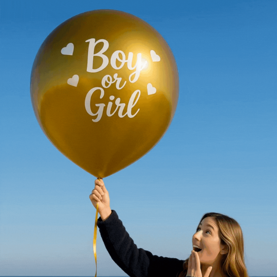 Deluxe Gold Mega Confetti Gender Reveal Balloon gold balloon with Boy or Girl text held by excited woman outdoors.