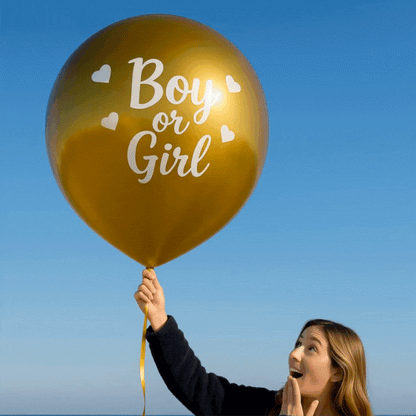 Deluxe Gold Mega Confetti Gender Reveal Balloon gold balloon with Boy or Girl text held by excited woman outdoors.