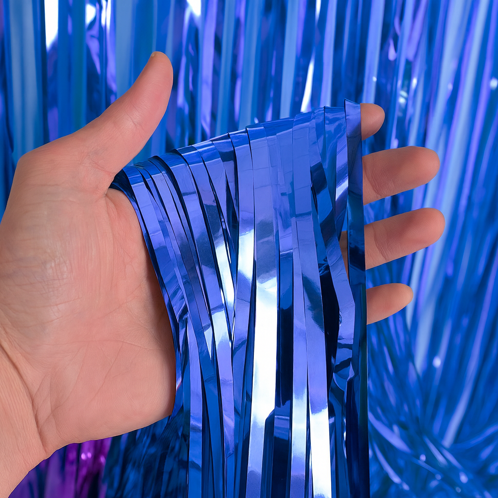 Gender Reveal Foil Party Curtain showing shiny blue metallic fringes held in hand, perfect for party decoration backdrop.