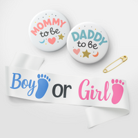 Mum and Dad to be badges and a white ribbon with blue and pink footprints reading Boy or Girl for gender reveal